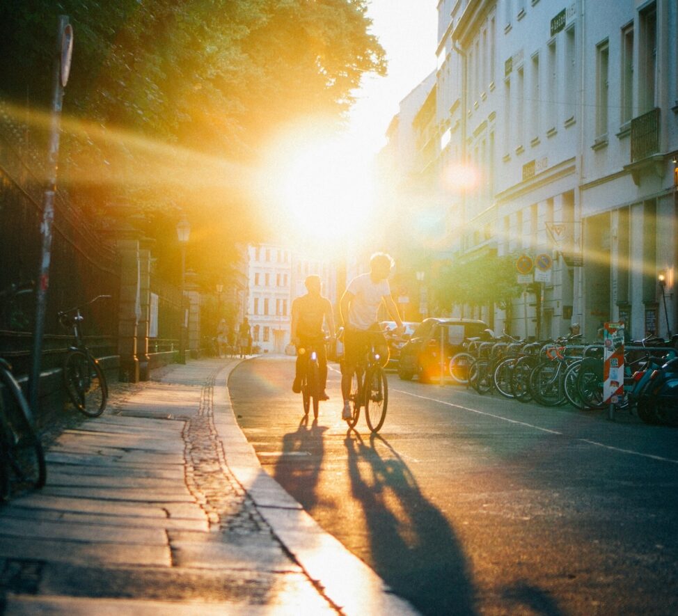 Zwei Personen auf Fahrrädern unter der Sonne.